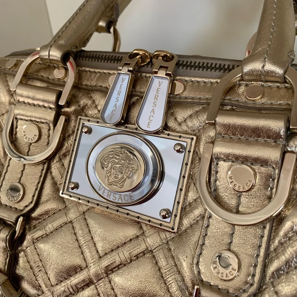 Hold Versace gold quilted handbag